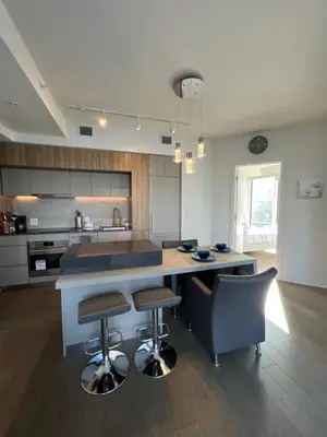 a kitchen with a table and two bar stools at Beautiful one bedroom downtown Condo with pool and free parking in Montréal