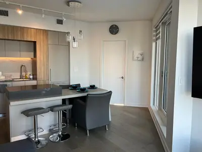 a kitchen with a counter and stools in it at Beautiful one bedroom downtown Condo with pool and free parking in Montréal