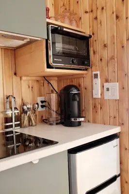 a kitchen with a microwave and a stove at Mi-clos - luxury pods with private jacuzzi and sauna in Orford