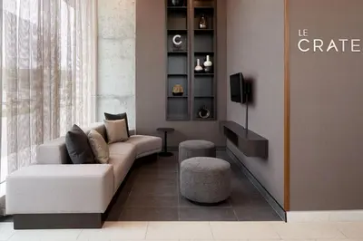 a living room with a couch and two stools at Courtyard by Marriott Montreal Laval in Laval
