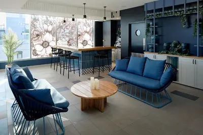 a living room with a blue couch and a table at Courtyard by Marriott Montreal Laval in Laval