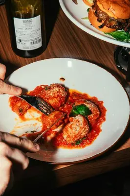 a person eating a plate of food with a fork and knife at Courtyard by Marriott Montreal Laval in Laval