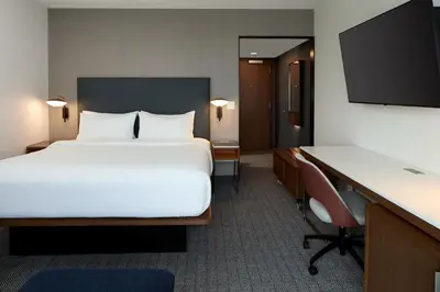 a hotel room with a large bed and a desk at Courtyard by Marriott Montreal Laval in Laval